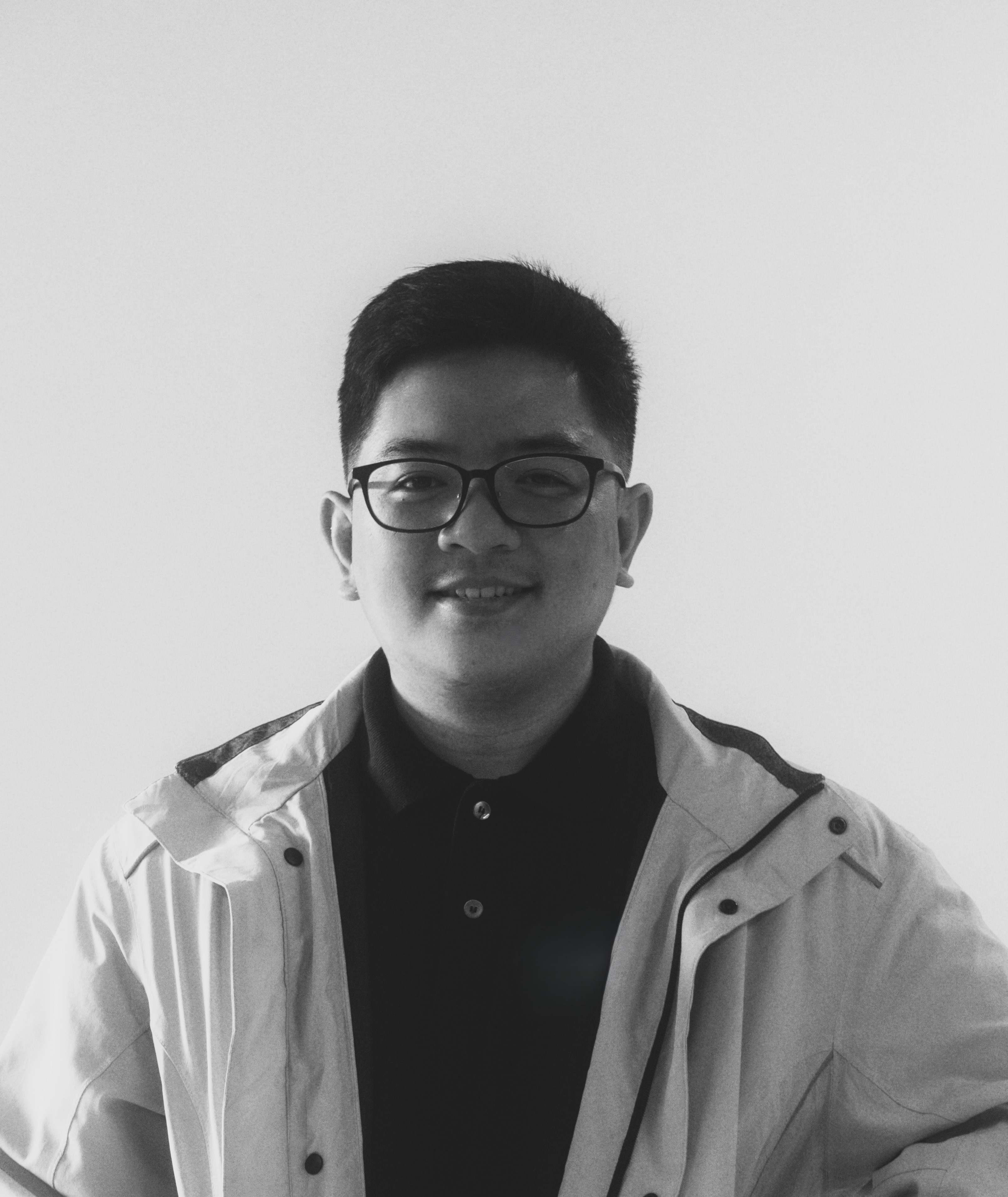 black and white photo of JP wearing a polo and jacket